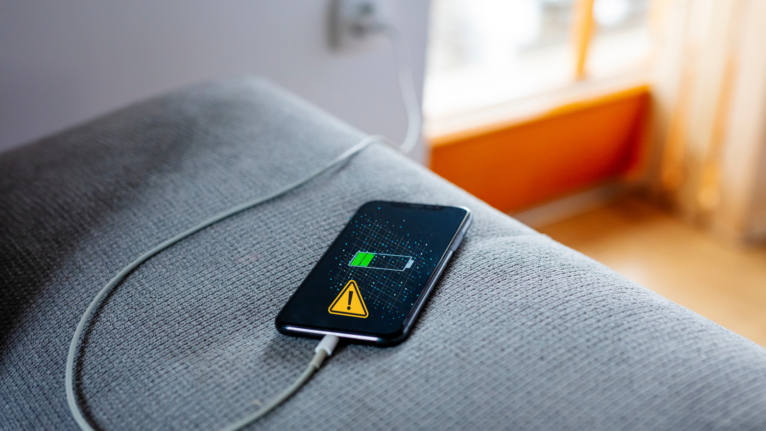 Phone charging via USB cable showing warning sign, symbolizing juice jacking and data theft risks